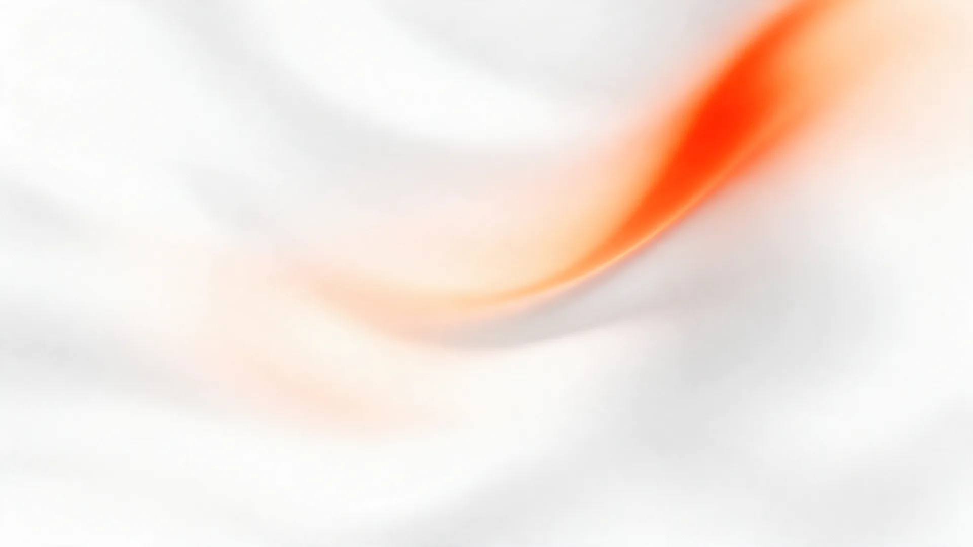 A soft curve of orange light on off-white, seen through a sheet of fluted glass.